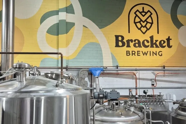 Brewing tanks at Bracket Brewing beneath the Bracket Brewing logo